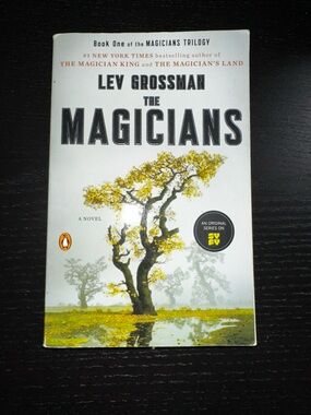 The Magicians Paperback Book with Yellow and Green Tree Artwork